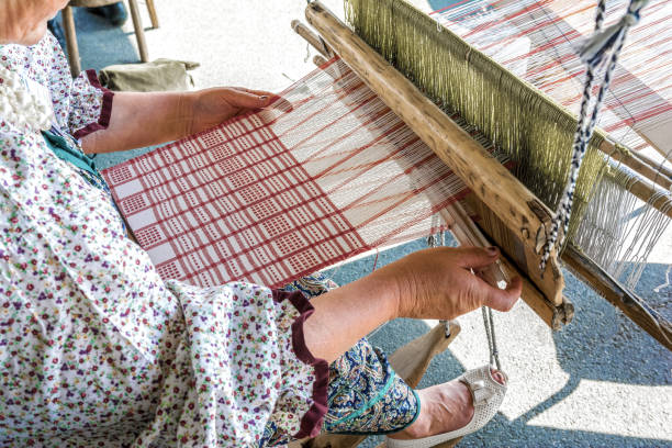 una mujer tejedora hace tela en un telar de mano. - women open traditional culture human hand fotografías e imágenes de stock