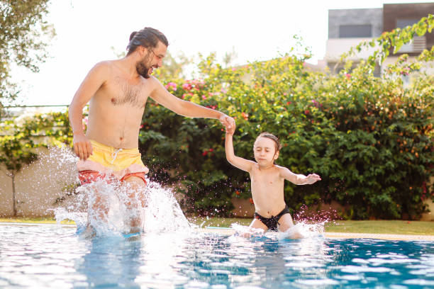 istock Cute little boy having fun with parents in pool 1336051520