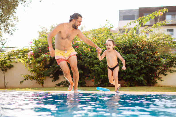 istock Cute little boy having fun with parents in pool 1336051604