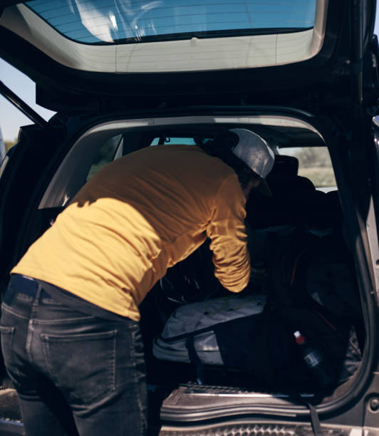 istock Windsurfer and camper packing and unpacking from a car in nature. 1336052307