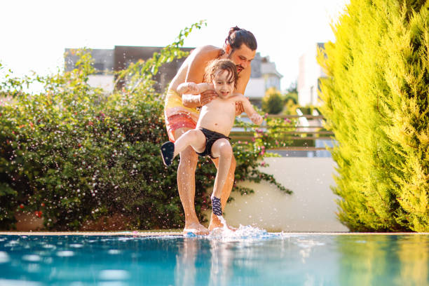 istock Cute little boy having fun with parents in pool 1336052317