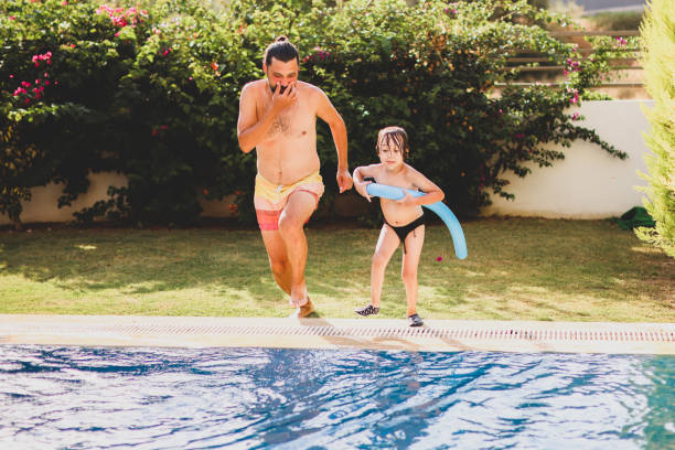 istock Cute little boy having fun with parents in pool 1336053012