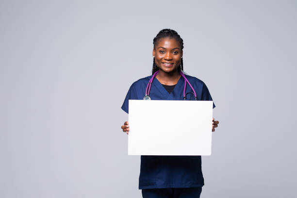 medico africano donna, medico professionista che lavora tenendo banner pubblicitario vuoto, buon poster per annuncio, offerta o annuncio, cartellone cartaceo. - holding a sign foto e immagini stock