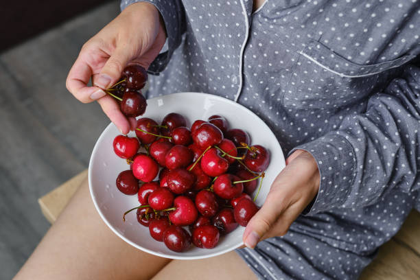 Girl holding a bowl with organic sweet cherries. The concept of proper nutrition, diet and lifestyle. Juicy berry close-up. Vegetable food. Fresh vitamins. Organic eco product, farm. Without GMO stock photo