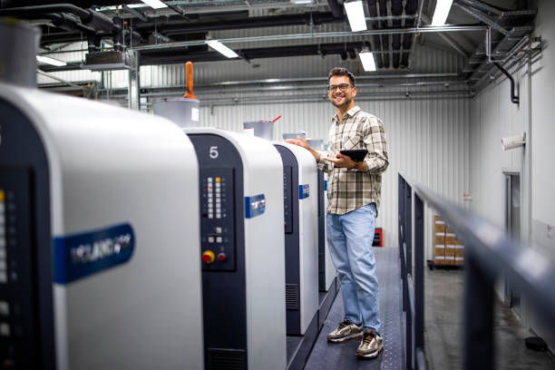 istock Portrait of professional graphic designer or engineer checking production on printing machine in print factory. 1336055652