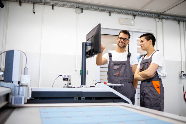 istock Experienced technician training new worker to operate CNC industrial machine in factory. 1336055735