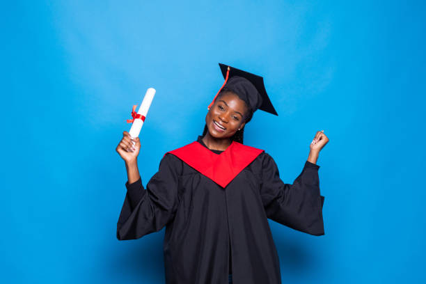istock Happy african student with graduation hat and diploma on blue background 1336056897