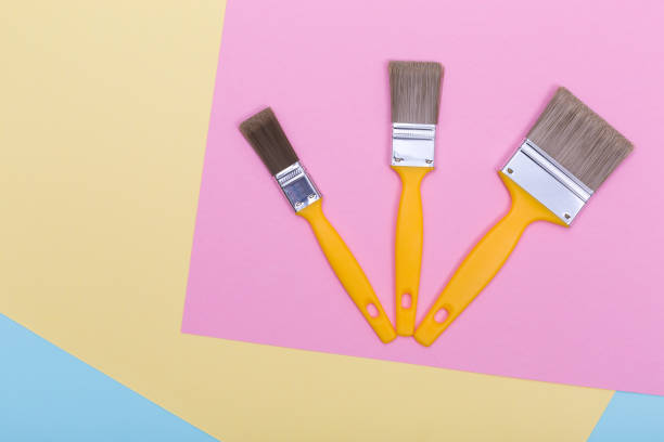 istock Three brushes for painting on pastel colored paper texture 1336058261