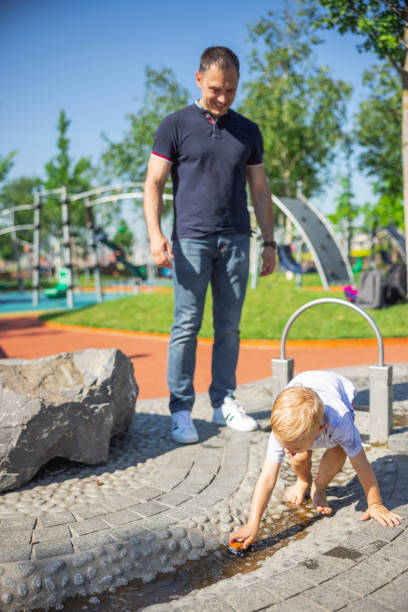 istock Smiling father watching his son play 1336059569