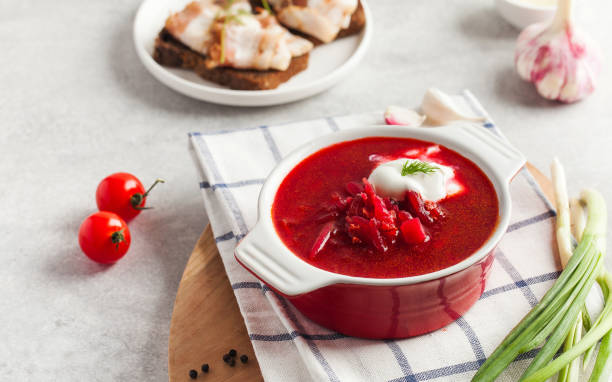 istock Delicious fresh red borscht, dark bread with lard and salt on kitchen table. 1336060644