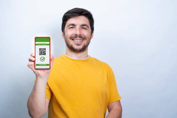istock Young man showing his Covid vaccine passport 1336061451