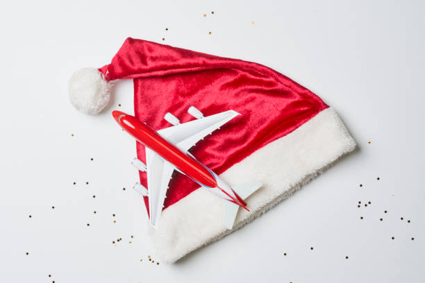 istock Christmas background with santa cap and airplane 1336062999