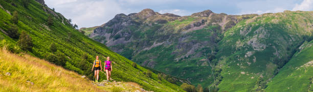 istock Young women hikers hiking on mountain path panorama Lake District 1336063162