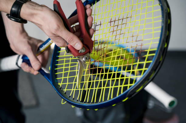 stringer coupe les cordes sur une raquette de tennis. préparation pour le remplacement de chaîne. - racket string photos et images de collection