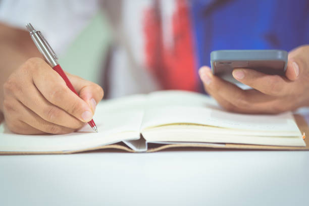 istock Closeup of a male student taking notes from learning lesson on a smartphone at home 1336068484