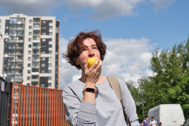 istock Woman is eating a nectarine on the street 1336070456
