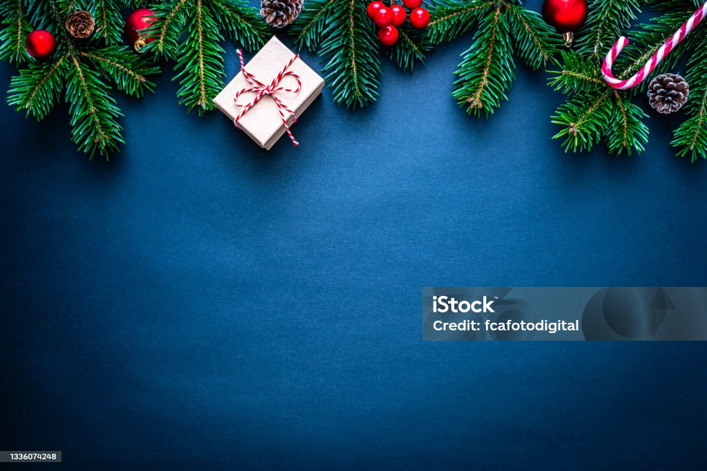 Blue Christmas and New year Holiday frame Blue Christmas frame with green branches and Christmas decoration. The composition is at the top of an horizontal frame leaving useful copy space for text and/or logo. Christmas Stock Photo