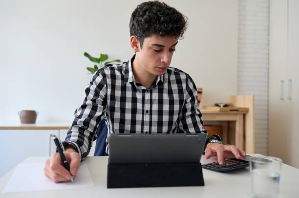 istock Young freelancer doing income tax return on laptop with calculator 1336075064