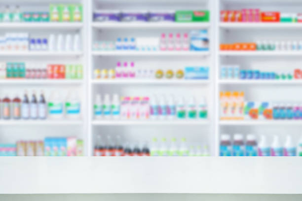 istock Empty white counter with pharmacy drugstore shelves blurred background 1336075780