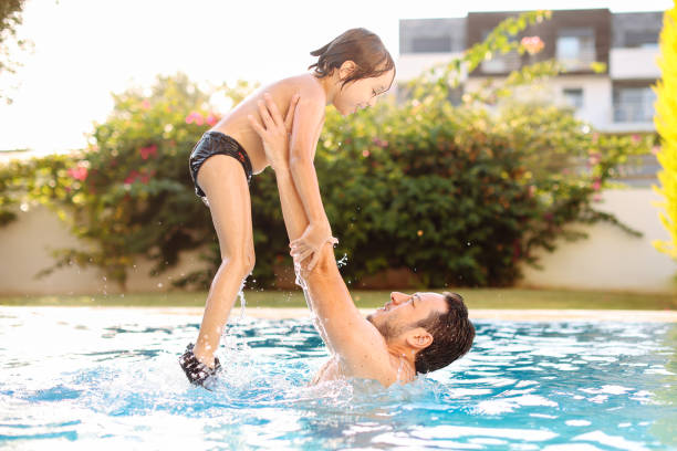 istock Cute little boy having fun with parents in pool 1336078076