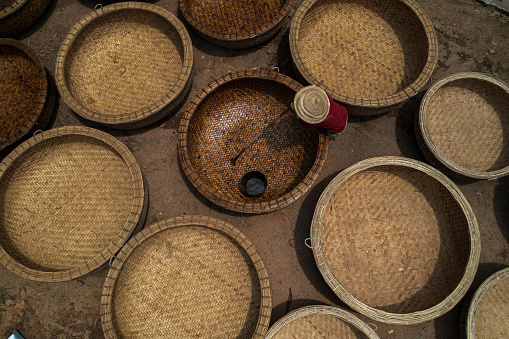 A woman worker is painting rotten oil on the basket boats, which make it