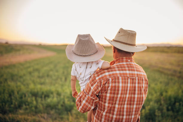 istock Senior farmer and grandson on a meadow 1336079811
