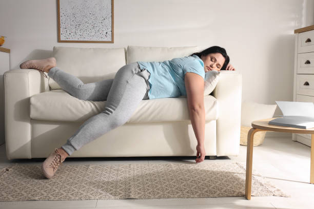 istock Lazy overweight woman resting on sofa at home 1336079954