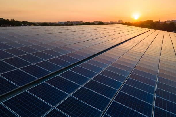 푸른 태양광 태양전지판이 일몰 에 깨끗한 생태 전기를 생산하기 위해 건물 지붕에 장착. 재생 에너지 개념의 생산. - 제어판 뉴스 사진 이미지