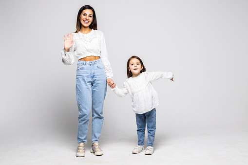 Mother and young daughter on a white background.