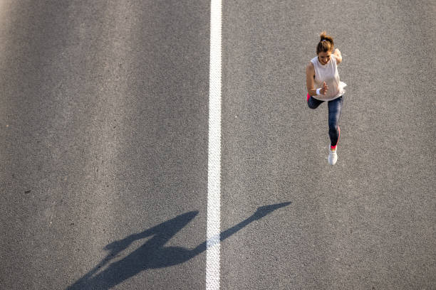 istock Young woman jogging on the road 1336082240