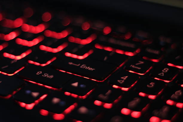 istock Close up of red laptop keyboards with under lights enter key button 1336082362