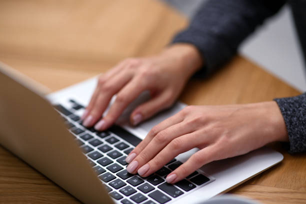 istock Woman working on modern laptop at table, closeup 1336086487