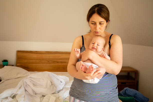 istock Mother Holding Baby At Home 1336086645