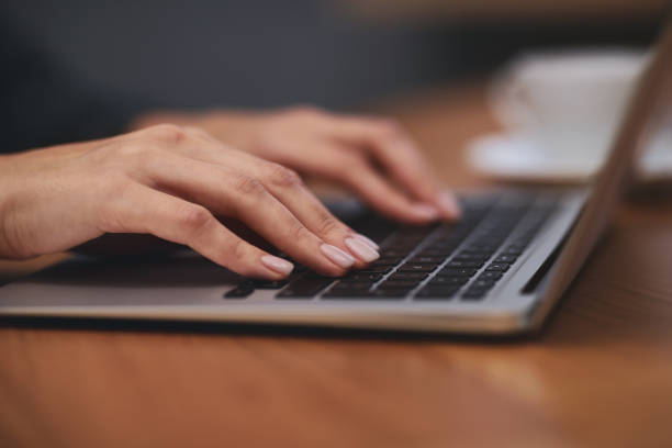 istock Woman working on modern laptop at table, closeup 1336086711