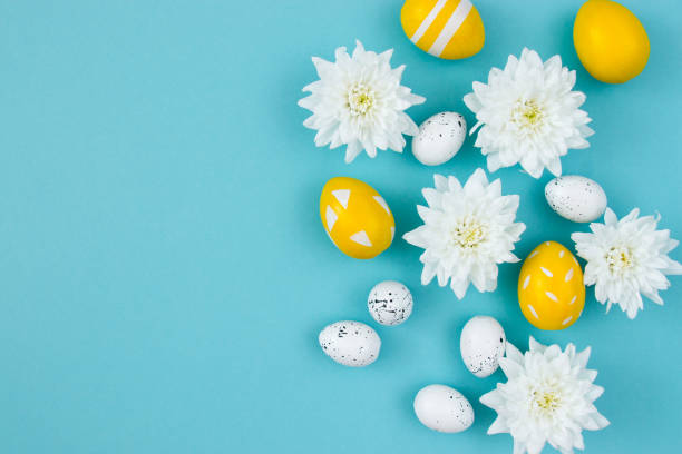 istock White flowers and painted Easter eggs on a blue background. Festive floral concept with clean text space. Flat lay. View from above. 1336087478