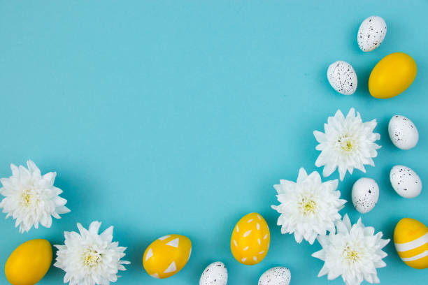 istock White flowers and painted Easter eggs on a blue background. Festive floral concept with clean text space. Flat lay. View from above. 1336087552