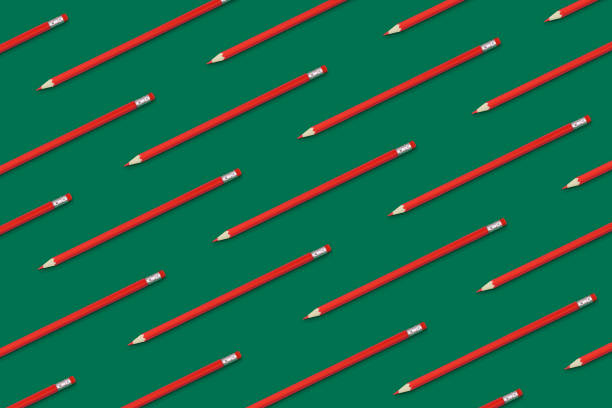 Pattern composition of red pencils on a green background. Top view. Flat lay. Back to school concept.