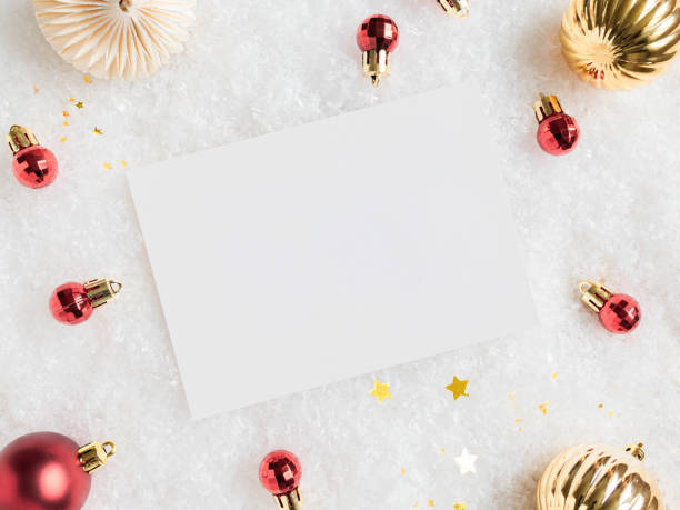 istock Empty white postcard and various red and gold christmas decor on artificial snow background. 1336088455