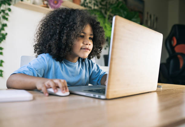 istock little afro boy, does homework at home with computer, back to school, homeschooling 1336092017