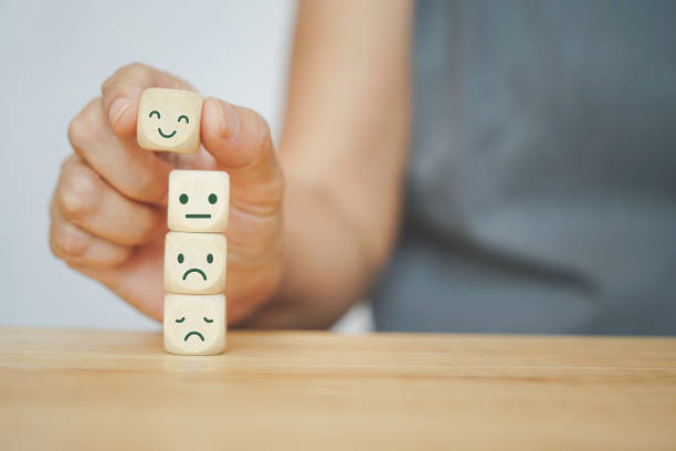 senior humano mano seleccionada cara feliz cubo de madera y otros en fondo verde para la evaluación de servicio al cliente, retroalimentación, encuesta de satisfacción o concepto de salud mental - quejándose fotografías e imágenes de stock