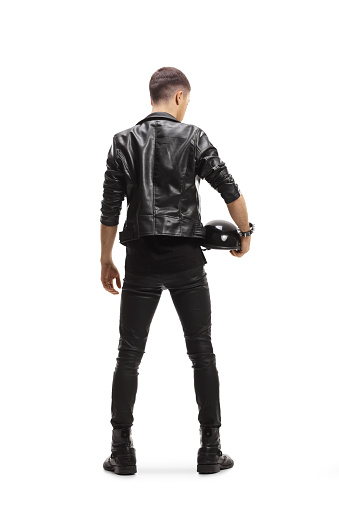 Full length rear view shot of a biker in a leather jacket holding a helmet isolated on white background