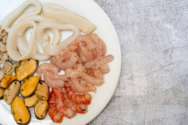 vista dall'alto di un piatto di pesce pulito pronto a fare una paella. calamari, vongole, cozze e gamberi. concetto di cibo sano. spazio di copia - prepared shellfish foto e immagini stock