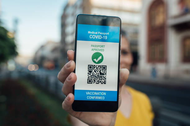 istock Woman holding a smartphone with vaccination certificate on the screen 1336099537