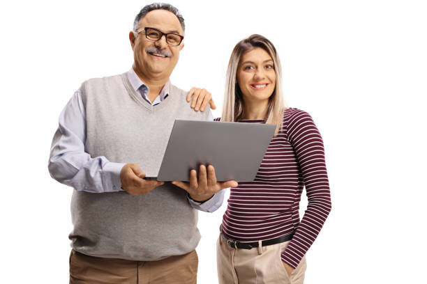 istock Young woman and an elderly man with a laptop computer looking at camera 1336099815