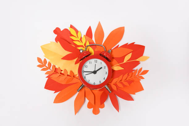 autumn red alarm clock with orange leaves on white background, fall time change - clock time alarm clock orange imagens e fotografias de stock