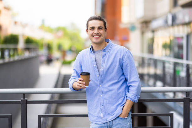 istock Handsome young man drinking coffee on street 1336104101