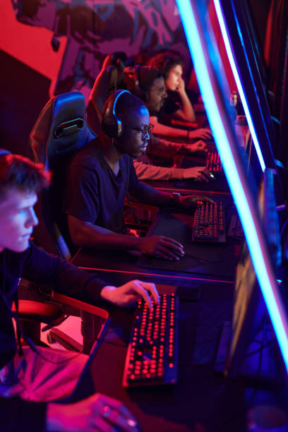 istock Group of serious young multi-ethnic men playing video games while participating in esports tournament, neon light 1336104132