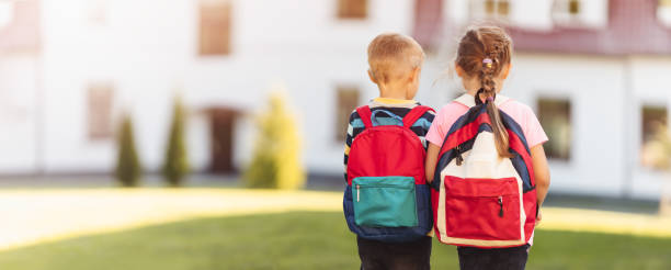 istock Children with backpacks going to the school 1336107413