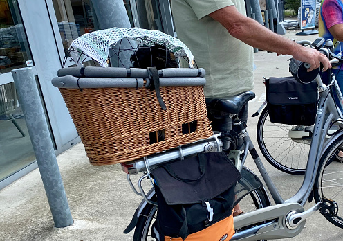 Heerlen,  the Netherlands, -  August24 2021. Senior couple with dog in carriage on the bag side of the bicycle.