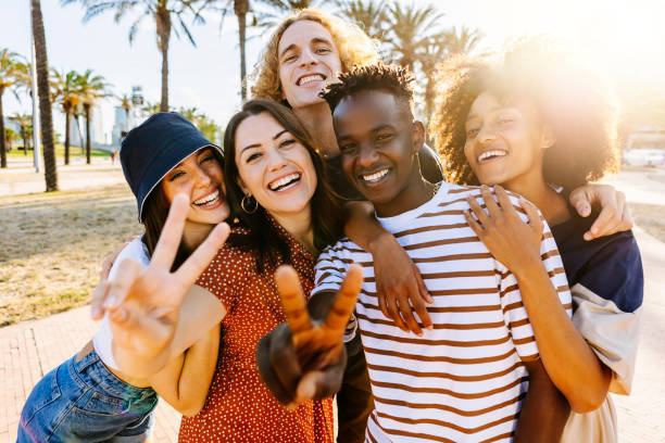 istock Portrait group of young multicultural trendy friends looking at camera while standing by palm trees background - Outdoor photo of diverse happy people having fun outdoors in summer - Focus on black guy 1336111114